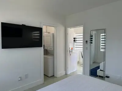 a bedroom with a flat screen tv on a wall at Villa Clara Blue-Little Havana in Miami