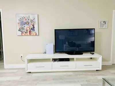 a flat screen tv sitting on a white entertainment center at Modern 1BR 1BA Condo 1Block to Aventura Mall in Aventura