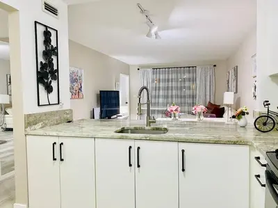 a kitchen with white cabinets and a sink at Modern 1BR 1BA Condo 1Block to Aventura Mall in Aventura