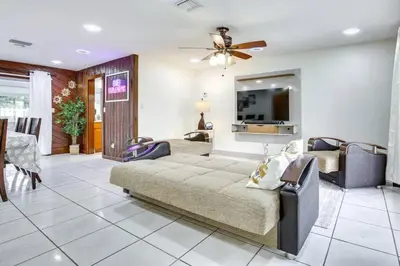 a living room with a bed and a tv at Oasis of Sunrise in Sunrise