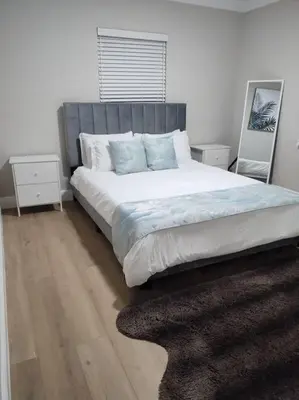 a bedroom with a large bed with blue pillows at Amazing Deal! Dania Beach Home with Pool & Jacuzzi in Dania Beach