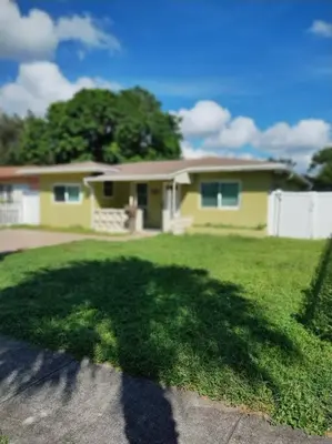 a house with a large shadow on the grass at Amazing Deal! Dania Beach Home with Pool & Jacuzzi in Dania Beach