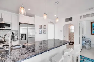 a kitchen with white cabinets and a counter top at Sunset Oceanfront Paradise in Hollywood