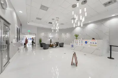 a lobby with white tile floors and chandeliers at Open the Window and Enjoy the Sea Breeze at Exclusive Condo! in Miami