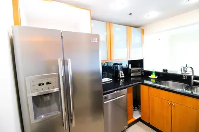 a kitchen with a stainless steel refrigerator and a sink at Castle L5 Oceanview Double-loft with pool, beach access, tennis, free parking! in Miami Beach