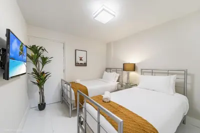 a bedroom with two beds and a tv at Sunny Isles Beachfront Oasis, Modern & Spacious in Sunny Isles Beach