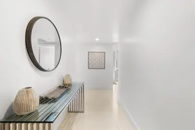 a hallway with a mirror and a console table at Escape to Beachwalk Resort in Chic Apartment in Hallandale Beach
