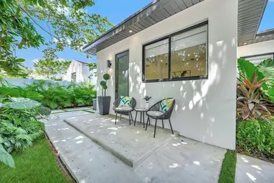 a patio with two chairs and a table in front of a house at Modern Oasis Near Design District, Wynwood in Miami