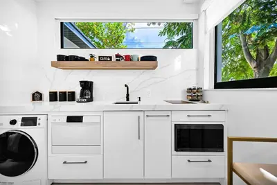 a white kitchen with a sink and a washing machine at Modern Oasis Near Design District, Wynwood in Miami