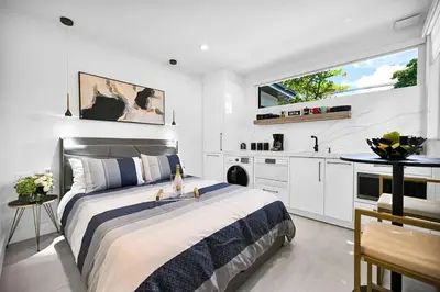 a bedroom with a large bed and a kitchen at Modern Oasis Near Design District, Wynwood in Miami