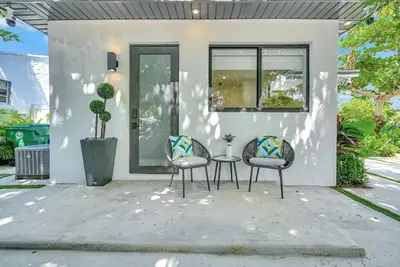 two chairs and a table in front of a house at Modern Oasis Near Design District, Wynwood in Miami