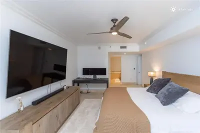 a bedroom with a large bed and a flat screen tv at Elegant Resort - Beautiful Views in Hallandale Beach