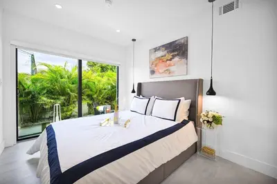 a bedroom with a large bed with a large window at Modern Private Oasis by Design District & Wynwood in Miami