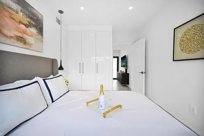 a bedroom with a white bed with a bottle on it at Modern Private Oasis by Design District & Wynwood in Miami