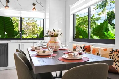 a dining room with a table and chairs and windows at Modern Private Oasis by Design District & Wynwood in Miami