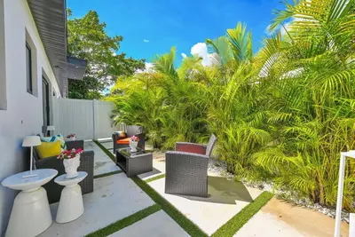 a patio with chairs and a toilet and palm trees at Modern Private Oasis by Design District & Wynwood in Miami