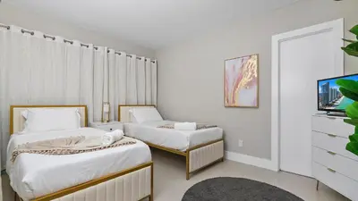 a hotel room with two beds and a tv at Absolute Beach Bliss, Chic & Expansive Retreat in Sunny Isles Beach