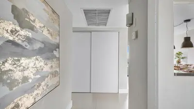 a hallway with a large painting on the wall at Absolute Beach Bliss, Chic & Expansive Retreat in Sunny Isles Beach
