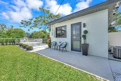 a white house with two chairs and a yard at Modern Studio Near Design District, Wynwood in Miami