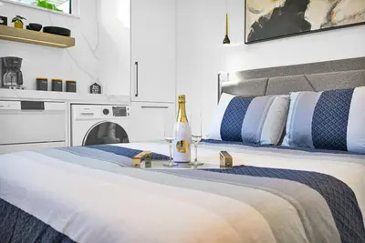 a white bedroom with a bed with a bottle of champagne at Modern Studio Near Design District, Wynwood in Miami