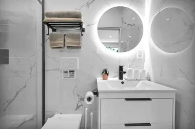 a white bathroom with a sink and a mirror at Modern Studio Near Design District, Wynwood in Miami