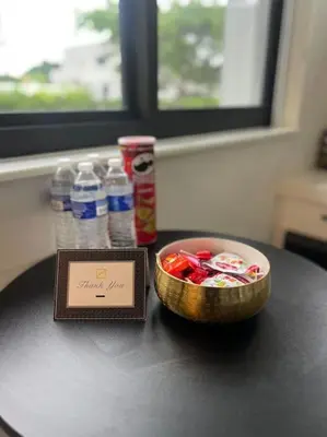 a table with a bowl of candy and bottles of water at Modern Studio Near Design District, Wynwood in Miami