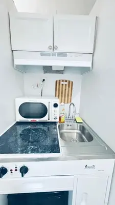 a small kitchen with a sink and a microwave at The Tiny Red Mini Studio At Little Havana in Miami