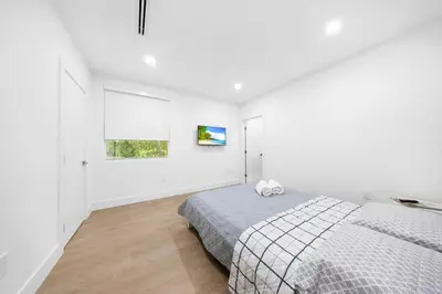 a white bedroom with a bed and a window at Up to 12 guests! Modern Villa near Wynwood 29! in Miami