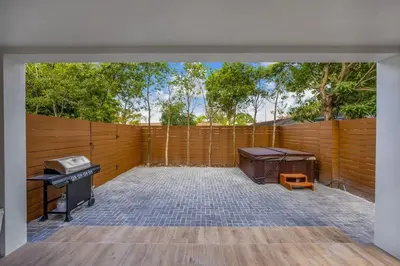 a backyard with a fence and a grill and a table at Up to 12 guests! Modern Villa near Wynwood 29! in Miami
