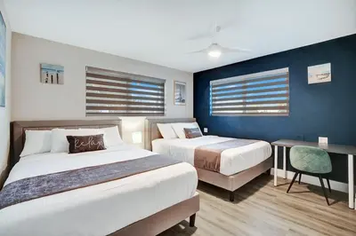 a hotel room with two beds and a desk at Ultimate Retreat 6BR & 3BA Villa near Beach in Dania Beach