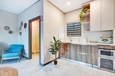 a kitchen with a sink and a blue chair at Ultimate Retreat 6BR & 3BA Villa near Beach in Dania Beach