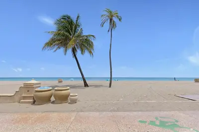 a sandy beach with palm trees and a sand castle at ULTRA peaceful 2 bedroom beach&boardwalk apartment in Hollywood