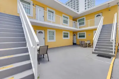 a building with stairs and a yellow wall at ULTRA peaceful 2 bedroom beach&boardwalk apartment in Hollywood