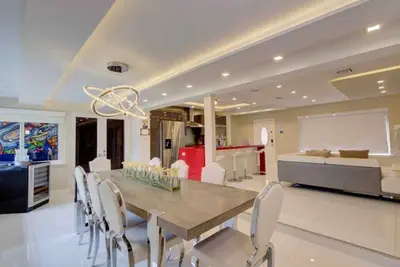 a dining room and living room with a table and chairs at The Palms Villa with Cinema, Game Table, Pool, Jacuzzi , Giant Chess, 8 Beds in Miami