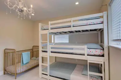 a bedroom with two bunk beds and a chandelier at The Palms Villa with Cinema, Game Table, Pool, Jacuzzi , Giant Chess, 8 Beds in Miami