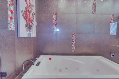 a bath tub in a bathroom with a tile wall at The Palms Villa with Cinema, Game Table, Pool, Jacuzzi , Giant Chess, 8 Beds in Miami