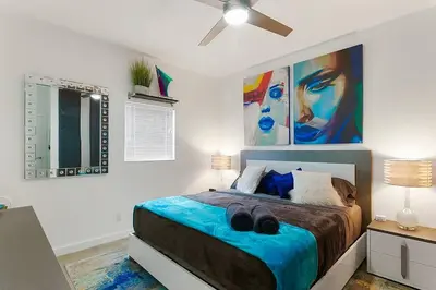 a bedroom with a bed with two shoes on it at Luxury Mansion, Game Room, Pool, Rooftop, Skyline, Walk to Las Olas in Fort Lauderdale