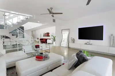 a living room with white furniture and a flat screen tv at Luxury Mansion, Game Room, Pool, Rooftop, Skyline, Walk to Las Olas in Fort Lauderdale