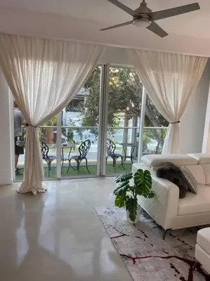 a living room with a couch and a ceiling fan at Luxury Mansion, Game Room, Pool, Rooftop, Skyline, Walk to Las Olas in Fort Lauderdale