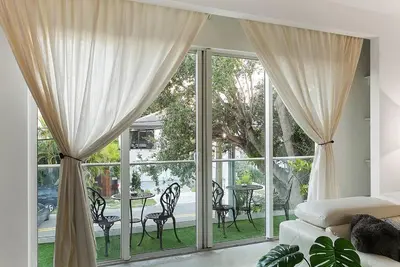 a bedroom with a large window with a table and chairs at Luxury Mansion, Game Room, Pool, Rooftop, Skyline, Walk to Las Olas in Fort Lauderdale