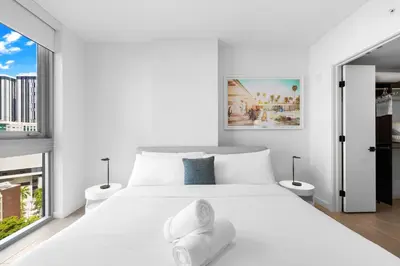 a white bedroom with a white bed and two windows at Luxury One-Bedroom w Top Amenities! in Miami