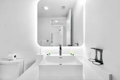 a white bathroom with a sink and a mirror at Luxury One-Bedroom w Top Amenities! in Miami