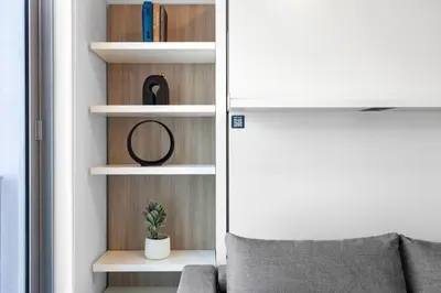 a living room with a chair and bookshelves at Luxury One-Bedroom w Top Amenities! in Miami