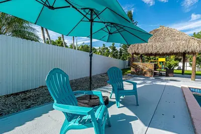two blue chairs and a table and an umbrella at Miami amazing location, Luxury & Spacious, Large pool, BBQ, Game room, Pool in Miami