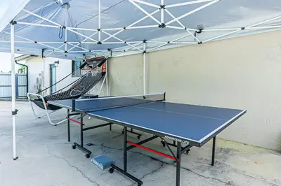 a ping pong table in a room with a tennis court at Miami amazing location, Luxury & Spacious, Large pool, BBQ, Game room, Pool in Miami