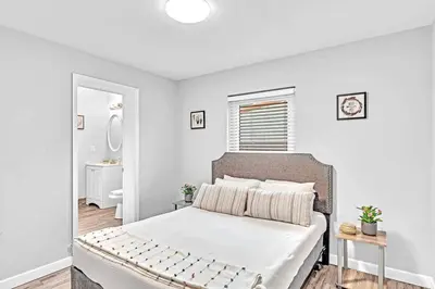 a white bedroom with a bed and a bathroom at 5 Minutes to Ocean & Casino's - Large Backyard in Hollywood