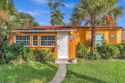 a yellow house with palm trees in front of it at 5 Minutes to Ocean & Casino's - Large Backyard in Hollywood