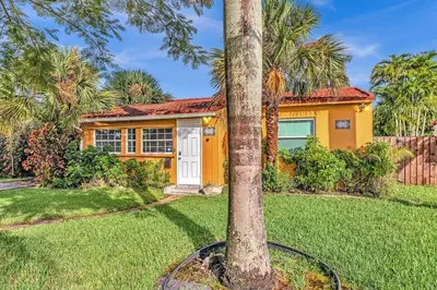a palm tree in front of a yellow house at 5 Minutes to Ocean & Casino's - Large Backyard in Hollywood