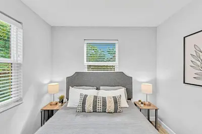 a white bedroom with a large bed with two lamps at 5 Minutes to Ocean & Casino's - Large Backyard in Hollywood