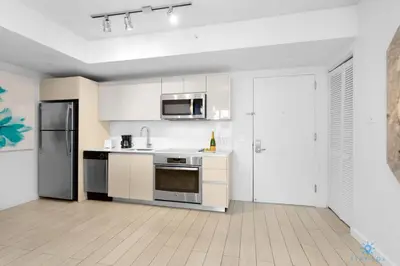 a kitchen with white cabinets and stainless steel appliances at Amazing Pool Infinity View and Gym in Hallandale Beach